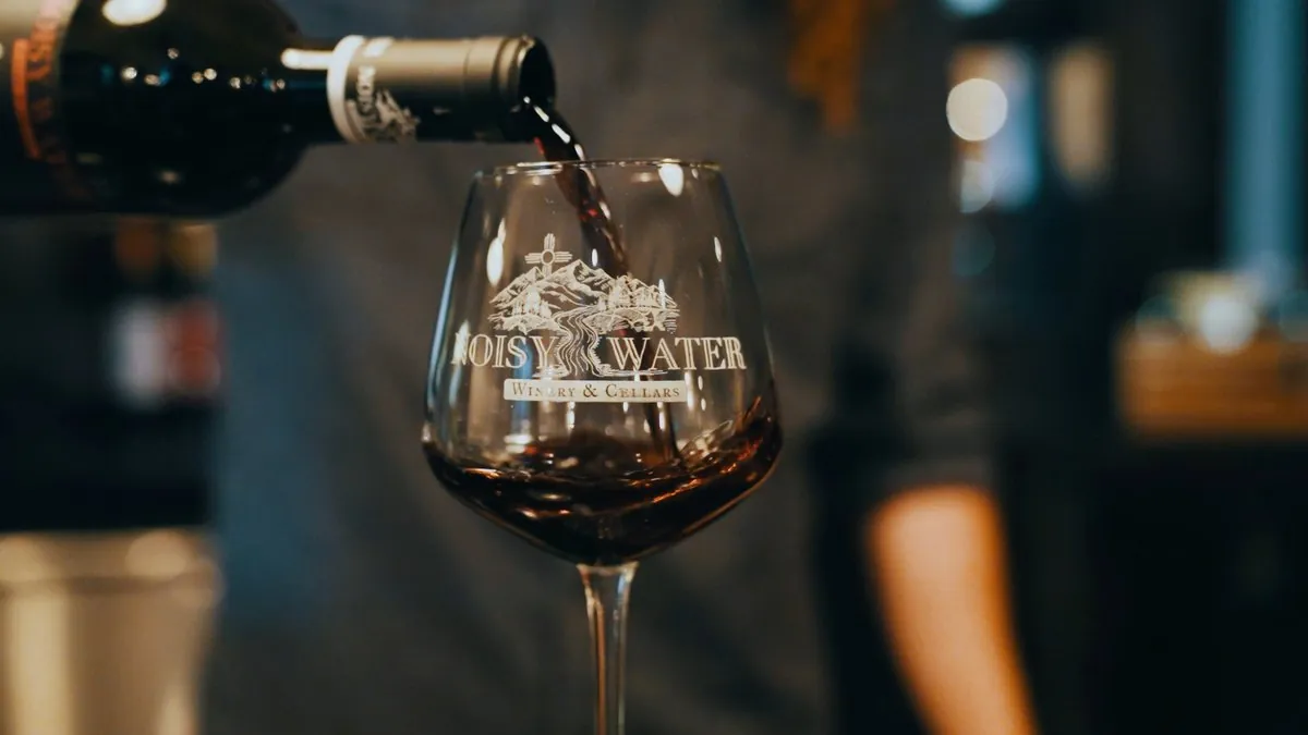Red wine being poured into a Noisy Water Winery glass